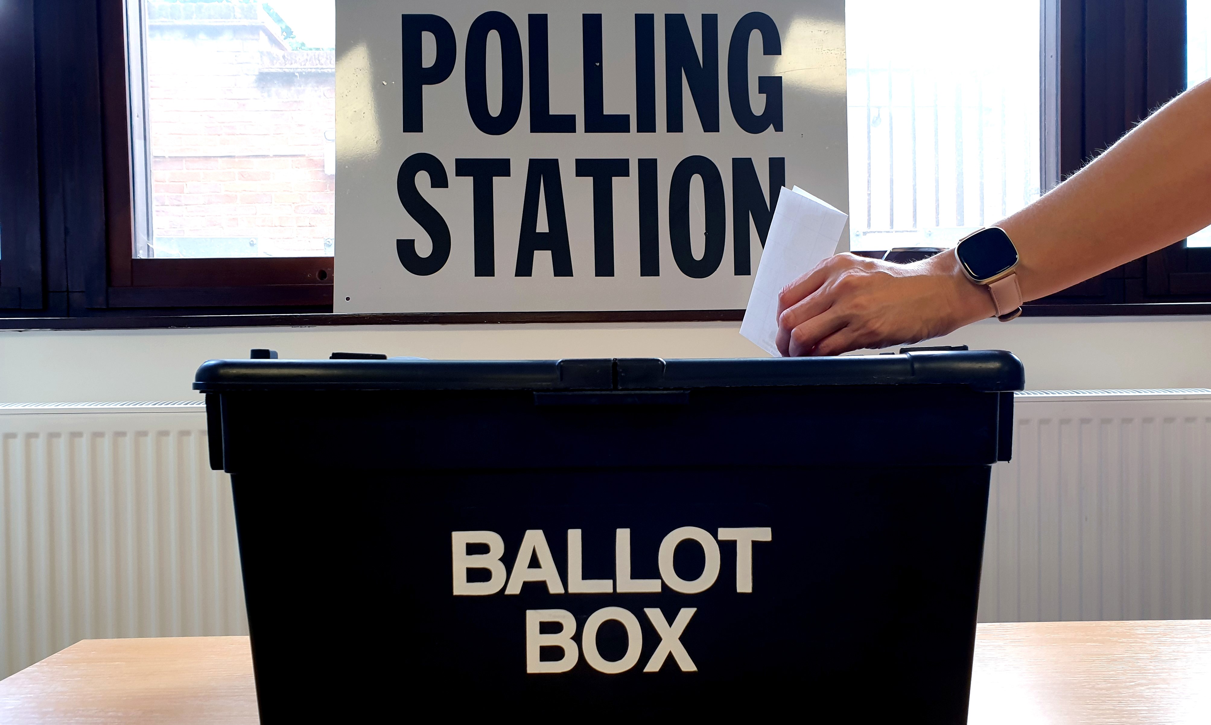 Photo of a hand placing a ballot paper into a ballot box