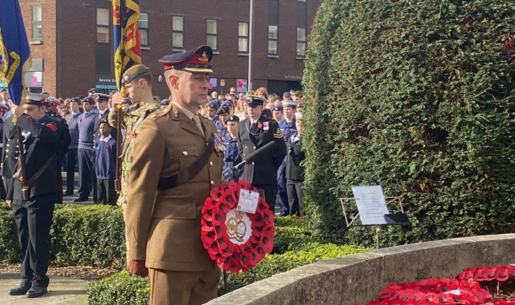 A person in uniform holding a wreath

AI-generated content may be incorrect.