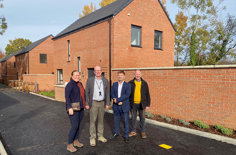 Title: A group of people standing in front of a brick building
AI-generated content may be incorrect.