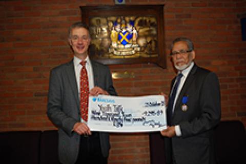 Cllr Councillor Mohammad Iqbal Zia presenting a cheque to Youth Talk's Trevor Fromant