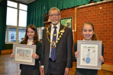 The Mayor of the City and District of St Albans, Councillor Mohammad Iqbal Zia, pictured with the two winners of the Christmas card competition, Siobhan and Ruby.