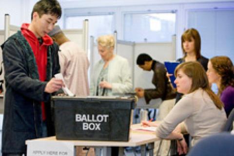 Person submitting their ballot paper into a ballot box